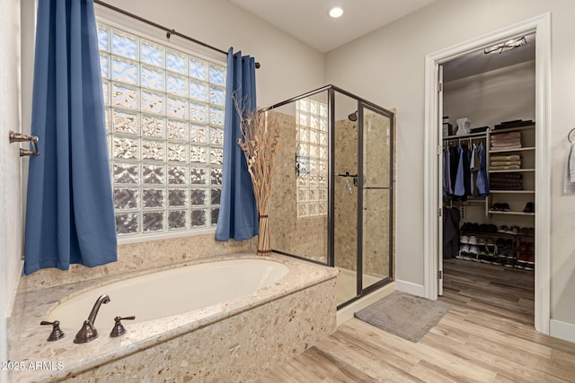 bathroom with hardwood / wood-style floors and shower with separate bathtub