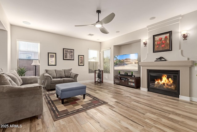 living room featuring ceiling fan and light hardwood / wood-style flooring