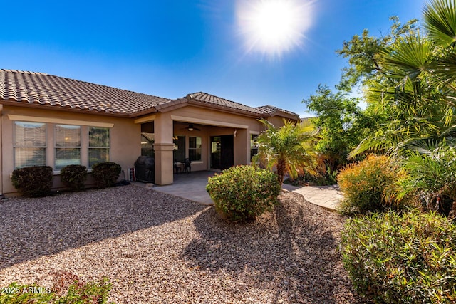 back of property with ceiling fan and a patio