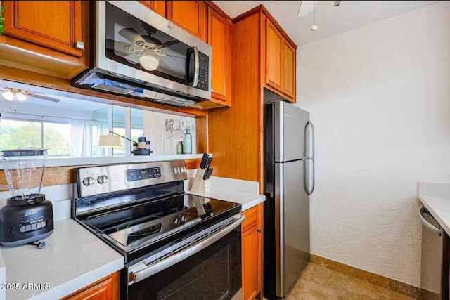 kitchen with light tile patterned flooring, ceiling fan, and stainless steel appliances