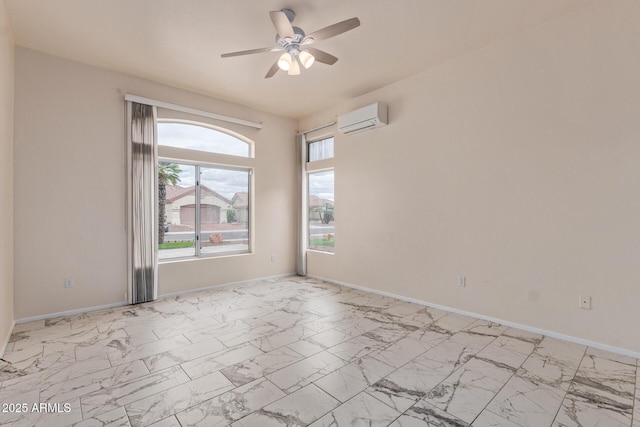 spare room featuring baseboards, marble finish floor, an AC wall unit, and ceiling fan