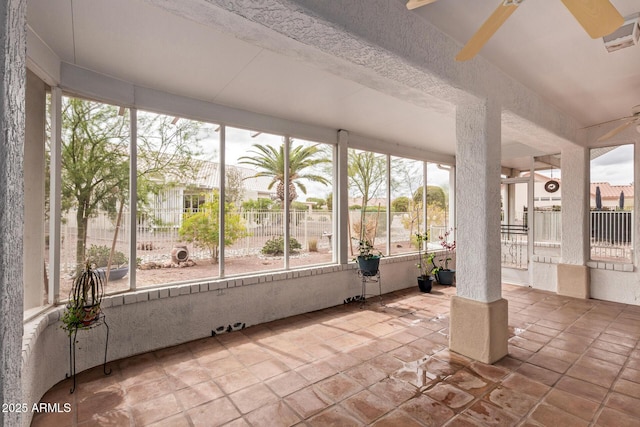 unfurnished sunroom with a ceiling fan