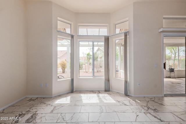 foyer entrance featuring baseboards and marble finish floor