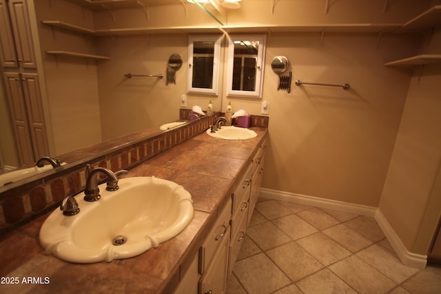 full bath with a closet, a sink, baseboards, and double vanity