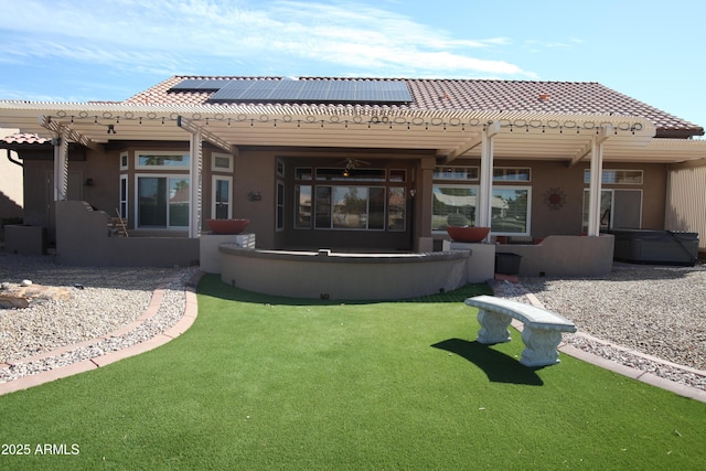 back of property featuring a patio, a tiled roof, roof mounted solar panels, stucco siding, and a pergola