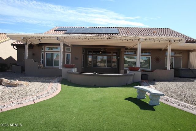 back of property featuring solar panels, a pergola, a tile roof, and stucco siding