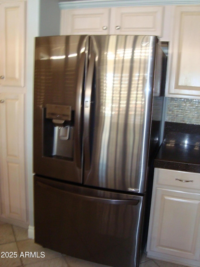 kitchen featuring tile countertops, light tile patterned flooring, white cabinets, stainless steel fridge with ice dispenser, and decorative backsplash