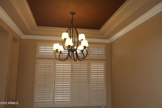 interior details featuring ornamental molding, a raised ceiling, and an inviting chandelier