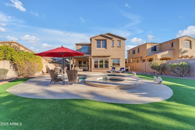 rear view of house featuring a swimming pool with hot tub, a patio area, and a lawn