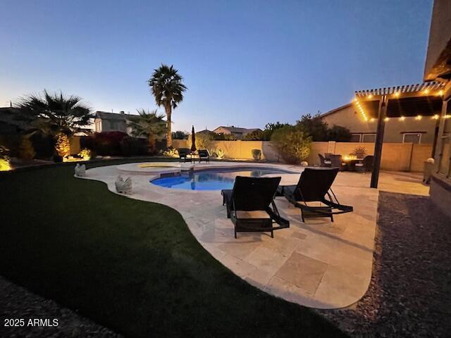 pool at dusk with a patio area