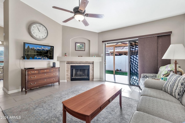 living room featuring ceiling fan and a tiled fireplace