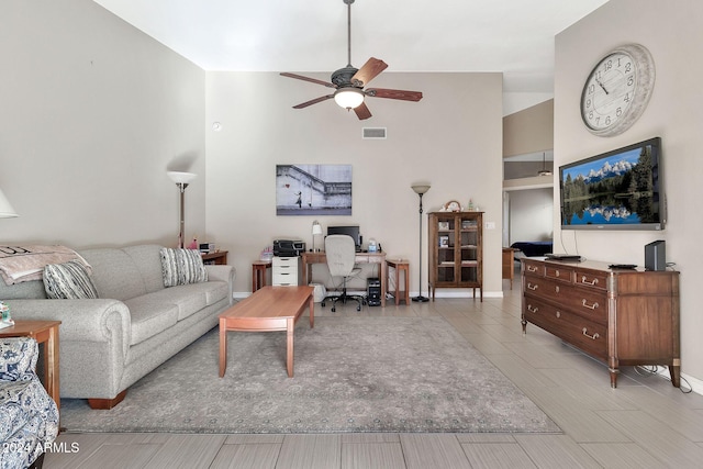 living room with ceiling fan and a towering ceiling