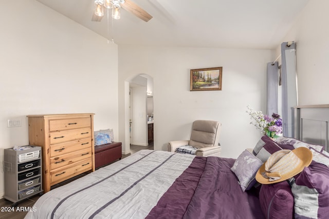 bedroom featuring ceiling fan, hardwood / wood-style floors, ensuite bathroom, and vaulted ceiling