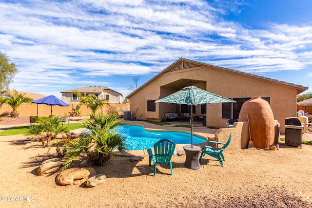 view of swimming pool featuring area for grilling, a patio area, and central air condition unit