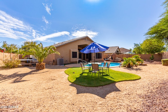 back of house featuring a fenced in pool, a patio, and central AC