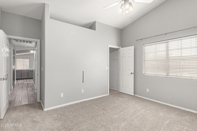 unfurnished bedroom with lofted ceiling, sink, and carpet flooring