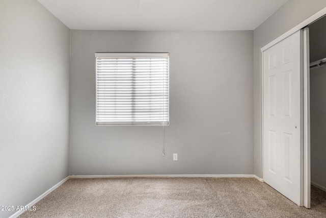 unfurnished bedroom with a closet and light carpet