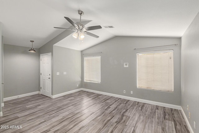 spare room with lofted ceiling, ceiling fan, and light hardwood / wood-style flooring