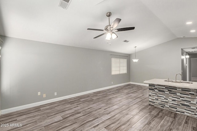 spare room with hardwood / wood-style flooring, ceiling fan, lofted ceiling, and sink