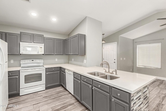 kitchen featuring gray cabinets, sink, white appliances, and kitchen peninsula