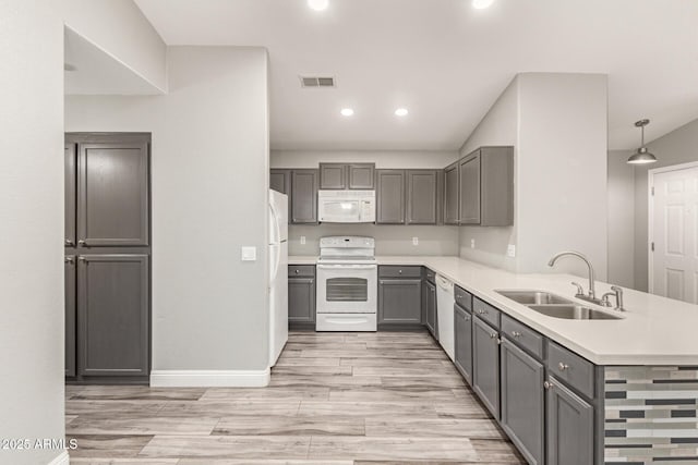 kitchen with gray cabinets, decorative light fixtures, sink, kitchen peninsula, and white appliances