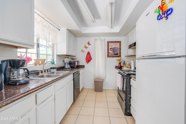 kitchen with black appliances, sink, a tray ceiling, light tile patterned flooring, and white cabinetry