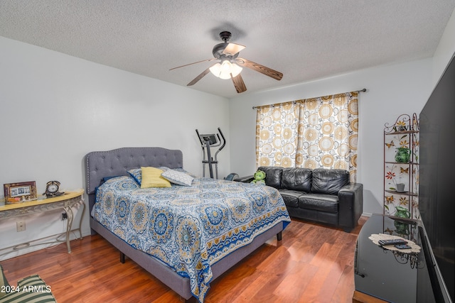 bedroom featuring dark hardwood / wood-style flooring, a textured ceiling, and ceiling fan