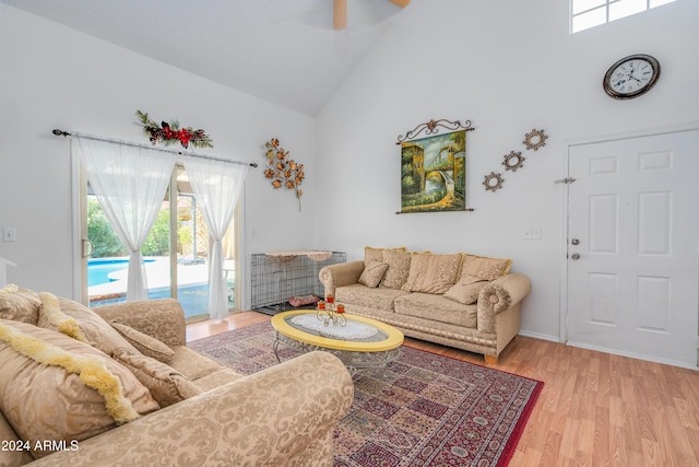 living room with high vaulted ceiling and light hardwood / wood-style flooring