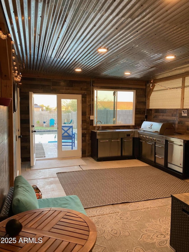 kitchen featuring wood ceiling, refrigerator, wood walls, and sink