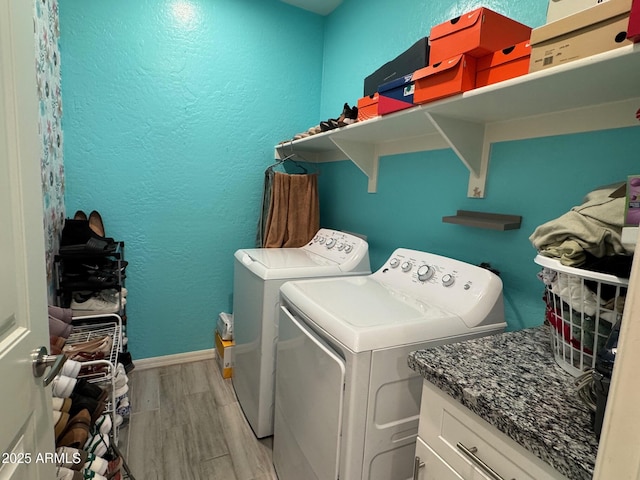 laundry area featuring cabinets, washing machine and dryer, and light hardwood / wood-style floors