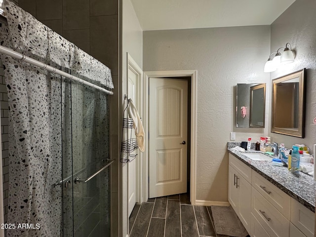 bathroom with vanity and a shower with door