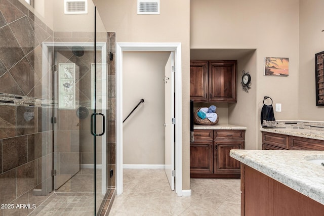 bathroom featuring tile patterned floors, an enclosed shower, and vanity