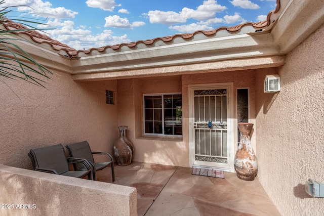 view of exterior entry with a patio