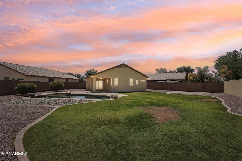 yard at dusk with a fenced in pool