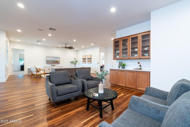 living area featuring a ceiling fan, dark wood finished floors, visible vents, and recessed lighting