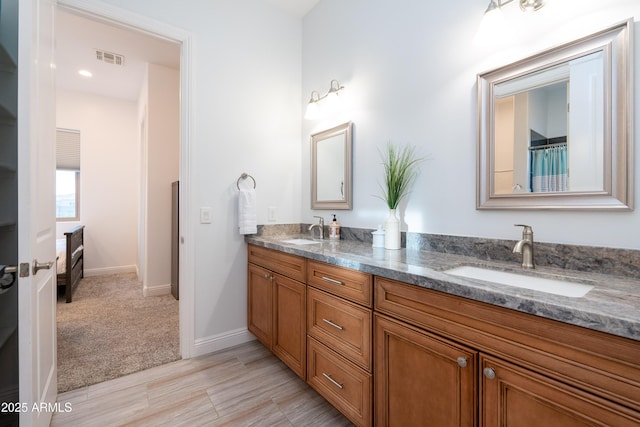 full bath featuring visible vents, a sink, baseboards, and double vanity