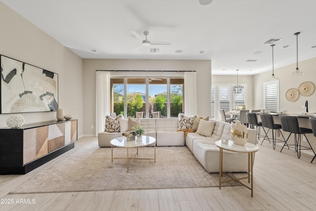 living room with light wood-type flooring and ceiling fan