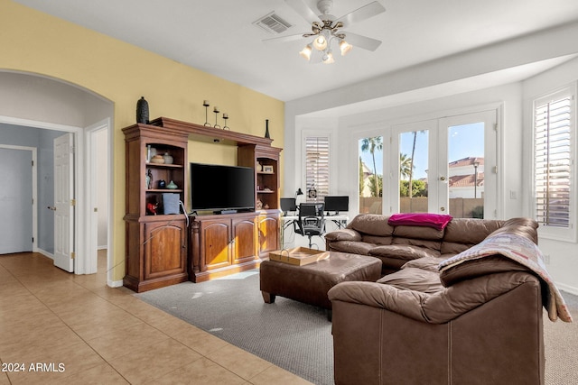 tiled living room featuring ceiling fan and french doors