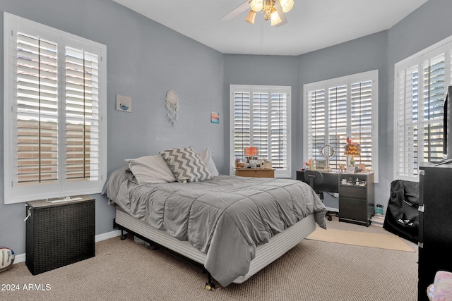 carpeted bedroom with ceiling fan and multiple windows