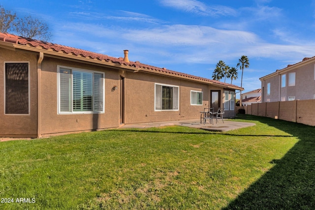 rear view of property featuring a patio and a yard