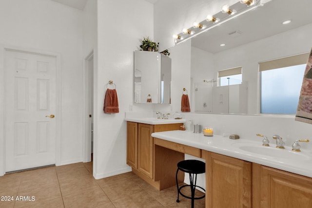 bathroom with walk in shower, vanity, and tile patterned floors