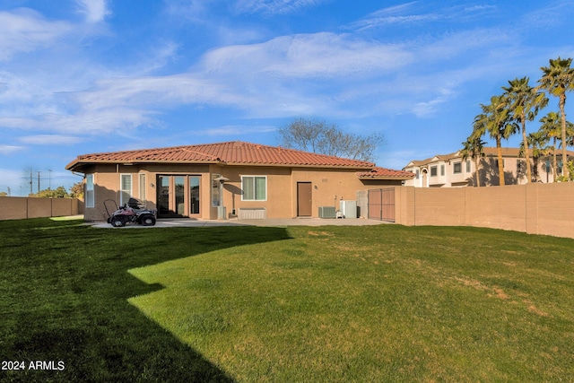 back of house with a lawn, a patio, and central AC