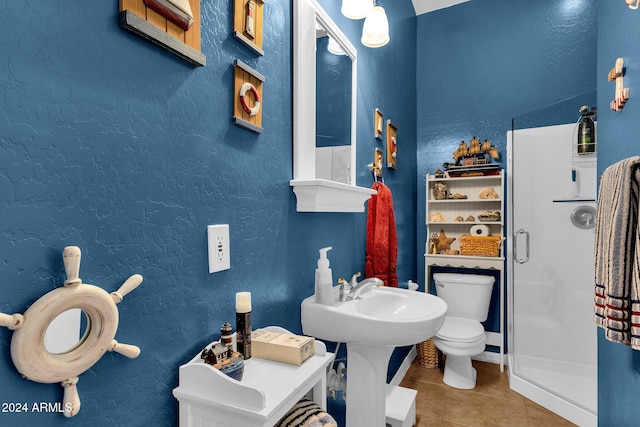 bathroom featuring tile patterned flooring, toilet, and a shower with shower door