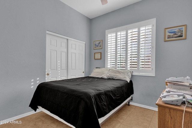 tiled bedroom featuring ceiling fan and a closet