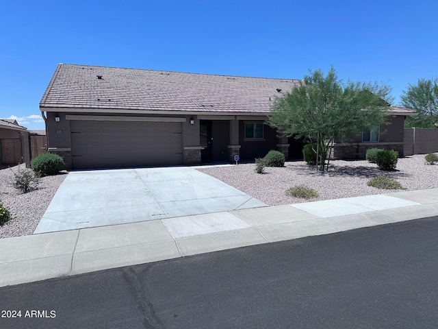 ranch-style home featuring an attached garage, fence, driveway, and stucco siding