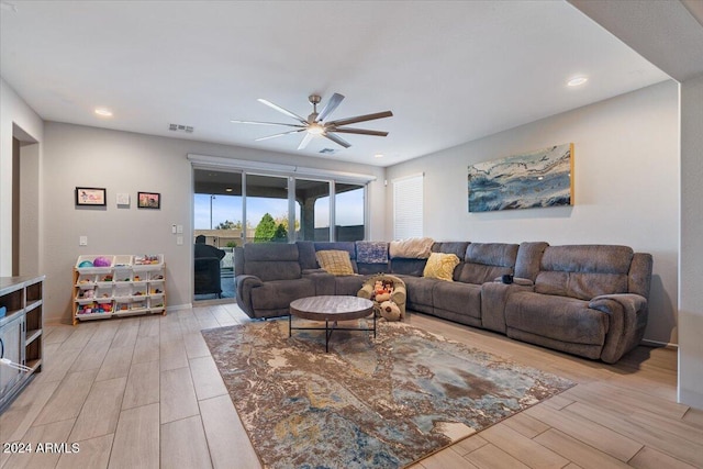 living room featuring ceiling fan and light hardwood / wood-style floors