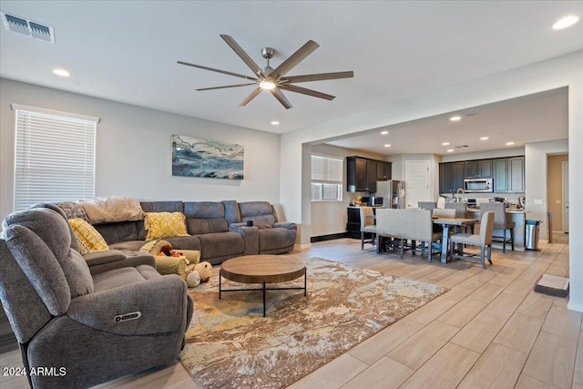 living room featuring ceiling fan and light wood-type flooring