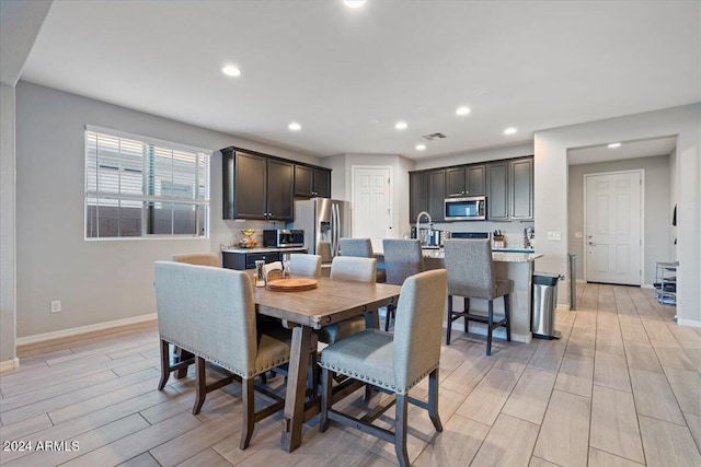 dining space with sink and light wood-type flooring