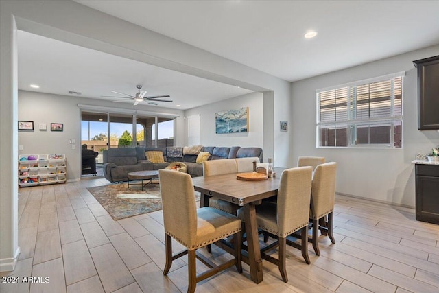 dining space with light wood-type flooring and ceiling fan