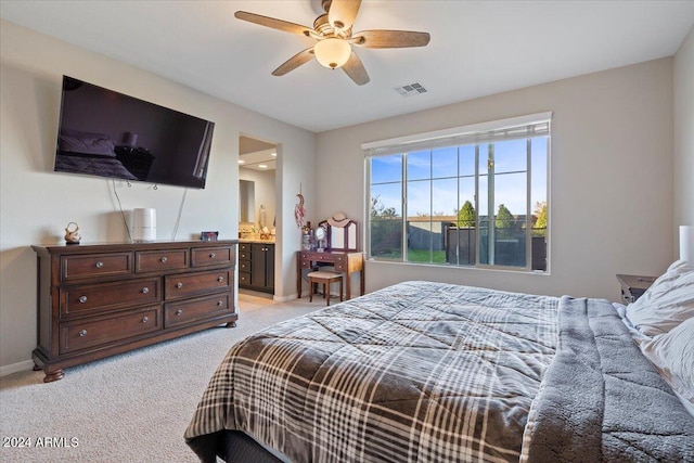 carpeted bedroom featuring ensuite bathroom and ceiling fan